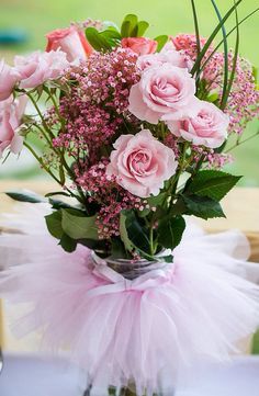 a vase filled with pink flowers sitting on top of a table next to other food