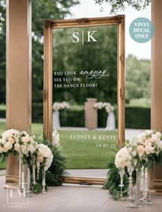 an outdoor ceremony with flowers and greenery in front of a large gold framed mirror