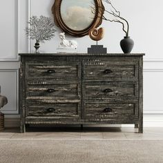 a wooden dresser sitting next to a mirror on top of a wall