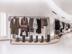 a clothing store with clothes and boots on display