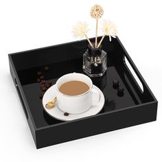 a cup of coffee on a black tray