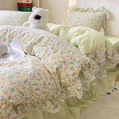 a teddy bear sitting on top of a bed next to pillows and sheets in a bedroom