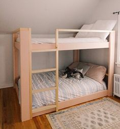 there is a bunk bed in the corner of this room with a rug on the floor