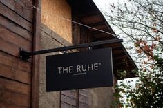 a sign hanging from the side of a building that says the rue collective on it