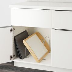 an open cabinet with two binders on the bottom and one hanging from the wall