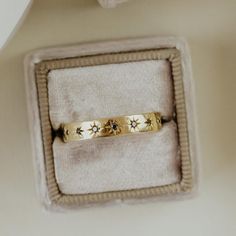 two gold rings sitting in a box on top of a table