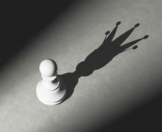 a chess pawn casting a shadow on the ground