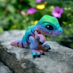 a small toy lizard sitting on top of a rock