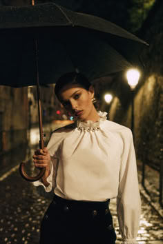 The Sézane Danty Blouse in ecru is a long-sleeved poplin blouse featuring a gathered high collar and intricate decorative pleats on the front. Accented with delicate gold pearls and gathered, elasticated cuffs, it’s finished with a subtle back slit closed with a button. Perfect for pairing with tailored trousers or skirts for a sophisticated winter wardrobe update. Check out our latest arrivals at sezane.com or via the app. High Collar Blouse, Blouse Elegant, Poplin Blouse, Wardrobe Update, High Collar, Organic Cotton