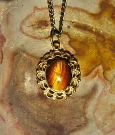 Here is a nice little vintage golden tiger's eye cabochon in a fancy gold-plated setting. The gemstone was curated from the estate of a talented lapidary artist in Oregon, probably cut and polished in the 1960s or 70s. I set it in an up-cycled gold filigree finding and paired it with an up-cycled 18 inch gold-plated chain. * Tiger's eye pendant is 23 x 18 mm * 18 inch gold-plated metal chain included All sales of my jewelry help fund our wildlife rescue and rehabilitation program. Thank you for Wildlife Rescue, Golden Tiger, Tigers Eye Necklace, Eye Pendant, Gold Filigree, Tiger's Eye, Eye Necklace, Metal Chain, Tiger Eye