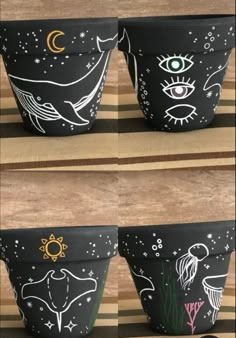 three black pots with drawings on them sitting on a striped tablecloth next to each other