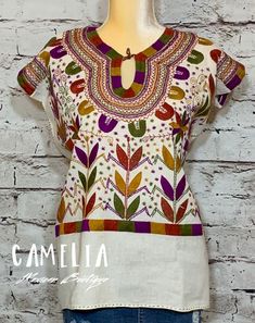 Hippie Boho Chic Santa Fe style blouse with corn motif Mayan design. Hand embroidered with fine thread on raw cotton (manta) with detail around neck and top of sleeve. Also available in 3/4 sleeve. ONE SIZE fits small, medium and large LARGE fits x-large and 2XL (pictured with size 18 mannequin) SIZE CHART: td {border: 1px solid #ccc;}br {mso-data-placement:same-cell;} CORN MOTIF MEXICAN BLOUSE SLEEVELESS WIDTH BUST LENGTH ONE SIZE 22" 44" 25.5" LARGE 25" 50" 27.5" Approximate measurements are i Bohemian Tops With Traditional Patterns For Summer, Traditional Cotton Top With Woven Motifs, Traditional Summer Tops With Traditional Patterns, Traditional Tops With Summer Patterns, Folk Style Cotton Top With Traditional Patterns, Cotton Tops With Traditional Patterns, White Cotton Tops With Traditional Patterns, Festival Tops With Traditional Patterns, White Cotton Top With Traditional Patterns