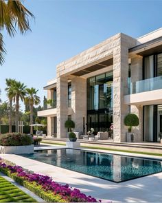 a large house with a pool in front of it and landscaping around the pool area