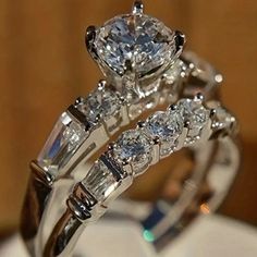 two wedding rings with diamonds on top of each other