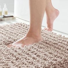 a woman's bare feet standing on a bathroom rug