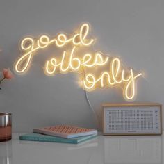 a neon sign that says good vibes only on the side of a wall next to a radio