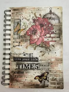 an altered book with flowers and a birdcage