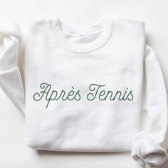 Après Tennis Sweatshirt I love to help my customers with custom orders, if you have a specific request (printing on the sleeve, design on a shirt, or a swap to a Comfort Colors sweatshirt), please message me and I will promptly get back to you! Please review the size chart in the images before you place your order. If you have any questions about sizing, I would be happy to help! If you don't see the specific color that you are looking for, please message me and I will get back to you quickly. PRODUCTION and SHIPPING Production takes about 1-3 days and standard shipping is 3-5 business days. If you are in a rush, please message me and I can help with shipping upgrades. RETURNS & EXCHANGES My goal is to ensure that my customers are completely satisfied with their purchase. If your product a Custom Print Cotton Sweatshirt For Sports Events, White Sweatshirt With Name Print And Relaxed Fit, White Sweatshirt With Name Print, Relaxed Fit, Relaxed Fit White Sweatshirt With Name Print, White Custom Print Sweatshirt For Sports Events, Sporty Cotton Sweatshirt With Custom Text, Sporty Crew Neck Sweatshirt With Custom Text, Sporty White Sweatshirt With Name Print, White Team Spirit Sweatshirt With Name Print