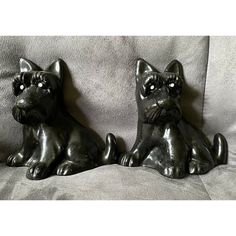 two metal cats sitting on top of a couch