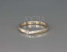 a gold wedding band with three diamonds on it