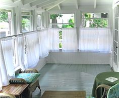 a porch with wicker furniture and white curtains