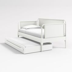 a white bed with a pull out trundle next to it