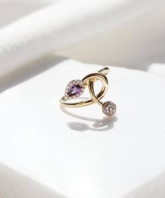 A beautiful and romantic 14K gold ring featuring a teardrop purple cubic zirconia stone and a little globe. This ring has a unique design and is one of a kind. We wont be making a second one of this ring, so if you love it hurry up! #february #birthstone #purple #ring #gold #aesthetic #minimalist #bridal #jewelry #unique Luxury Rose Gold Infinity Jewelry, Luxury Infinity Jewelry With Cubic Zirconia, Luxury Cubic Zirconia Infinity Jewelry, Luxury Infinity-shaped Cubic Zirconia Jewelry, Elegant Infinity Gemstone Jewelry, White Gold Infinity Fine Jewelry, Fine Jewelry Infinity Shape For Formal Occasions, Infinity Halo Jewelry Gift, Fine Jewelry With Infinity Gemstone