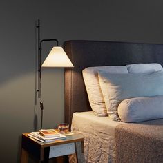 a bedroom with a bed, nightstand and lamp