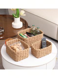 two wicker baskets sitting on top of a coffee table next to a remote control