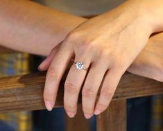 a close up of a person's hand with a diamond ring on their finger