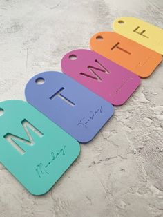 four different colored tags with the word wti written on them in cursive writing