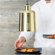 a person holding a plate with food on it and a bell hanging from the ceiling