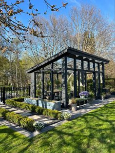 a small glass house sitting on top of a lush green field