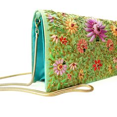 "Stunning one-of-a-kind statement clutch, a lush garden of glowing silk flowers hand embroidered on a rich turquoise/green silk background, and embellished with metallic threads and genuine star ruby stones. The sumptuous luster of silk and the exquisite embroidery make this a show stopping purse! The lotus flower is a symbol of rebirth and new beginnings - perfect for weddings and life's transitions. The word Zardozi means \"gold thread\". It is an elaborate and intricate embroidery using metal Elegant Turquoise Bag For Formal Occasions, Green Rectangular Shoulder Bag With Floral Embroidery, Turquoise Rectangular Evening Shoulder Bag, Turquoise Rectangular Shoulder Bag For Evening, Evening Bags With Floral Embroidery For Festivals, Luxury Embroidered Green Bag, Luxury Green Embroidered Bag, Handmade Green Evening Bag, Luxury Green Evening Bag For Gifting