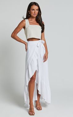 Get ready to turn heads with the Donita Midi Skirt in White! This playful and flirty wrap skirt is perfect for those casual days when you want to look effortlessly chic. Made from a textured woven cotton fabric, this midi skirt is comfortable and breathable, keeping you cool all day long. With its flattering wrap design, it cinches at the waist to create an hourglass silhouette that accentuates your curves in all the right places. Pair it with a cute crop top and sandals for a fun and feminine l Breezy Ruffled Maxi Skirt For Summer, Breezy Ruffled Maxi Skirt For Beach, Breezy Beach Maxi Skirt With Ruffles, Breezy Ruffled Maxi Skirt For Vacation, Flowy Cotton Maxi Skirt For Day Out, Summer Midi Skirt With Tie Waist, Summer Lined Asymmetrical Skirt, Summer Asymmetrical Lined Skirt, Flowy Beach Wrap Skirt