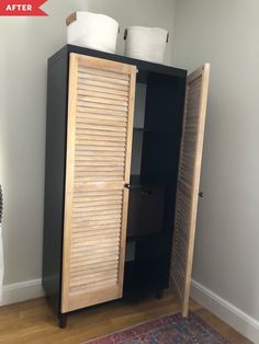 a wooden cabinet with two white baskets on top of it and a rug in front of it