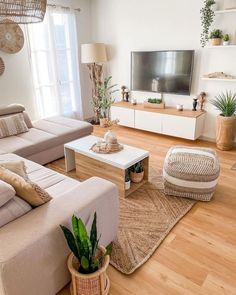 a living room filled with furniture and a flat screen tv on top of a wooden table