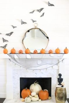 a fireplace decorated for halloween with pumpkins and bats