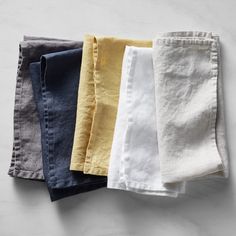 five different colored linen napkins laid on top of each other