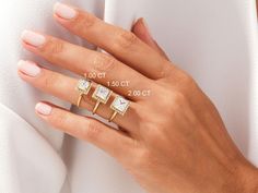 a woman's hand with three rings on her fingers and the ring is gold