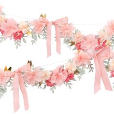 two pink flowers are tied to a string with ribbons and bows on it, as if for an anniversary or special occasion