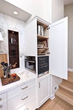 a kitchen with white cabinets and wooden floors