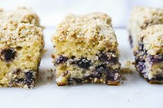 four pieces of blueberry crumb cake on a white surface