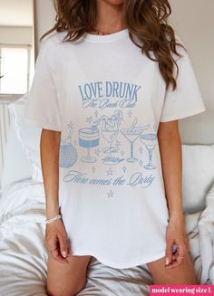 Raise a glass to love with this trendy "Love Drunk" tee. Perfect for celebrating the bride-to-be, this playful top is a must-have for any bachelorette party. Let the good times roll! Don't forget grab the matching shirt for the Bride-to-Be! White Summer Top For Hen Party, White Short Sleeve T-shirt For Bachelorette Party, White Letter Print Top For Bachelorette Party, White Short Sleeve Top For Bachelorette Party, White Short Sleeve Top For Hen Party, Hen Party Short Sleeve T-shirt With Letter Print, Graphic Tee For Bachelorette Party With Short Sleeves, Short Sleeve T-shirt For Hen Party With Letter Print, Graphic Tee Tops For Bachelorette Party