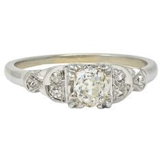 an antique diamond ring with three stone shoulders