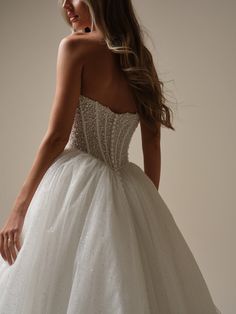 a woman in a wedding dress is posing for the camera with her hand on her hip