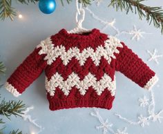 a red and white sweater hanging from a christmas tree