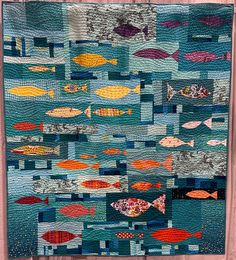 a quilted wall hanging with fish on it