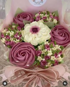 a pink and white bouquet in a clear box