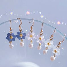 five pairs of dangling earrings on a glass plate